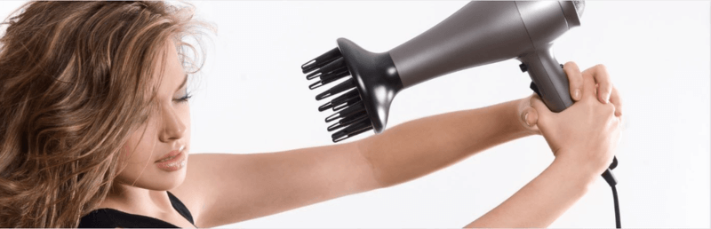 femme qui pointe un sèche-cheveux vers elle