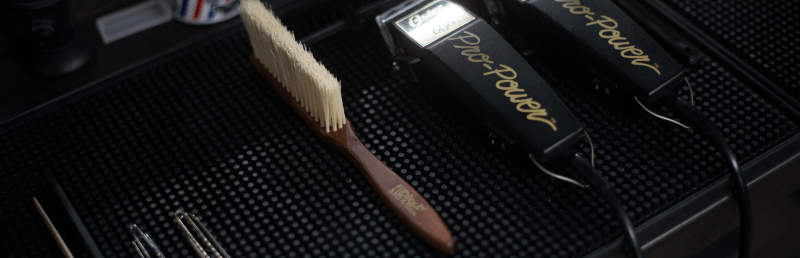 plan de travail d'un barbier avec des tondeuses et une brosse